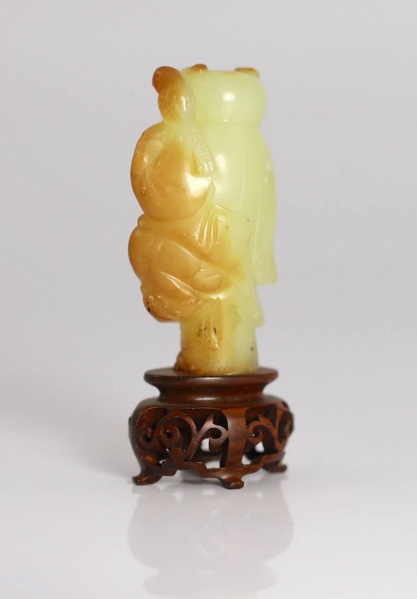 A rare Chinese yellow and russet jade figure of a boy holding a parrot, 18th/19th century, 5.6cm high, wood stand